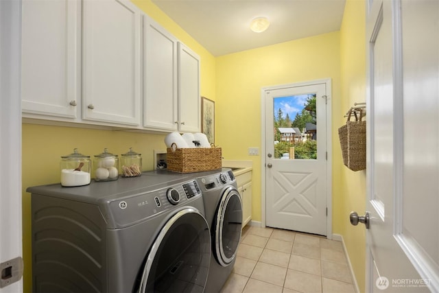 laundry room with washing machine and dryer, light tile patterned flooring, cabinet space, and baseboards