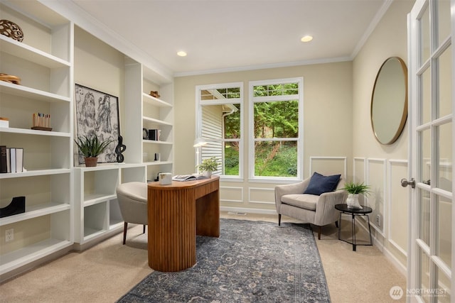 carpeted office with built in shelves, recessed lighting, french doors, crown molding, and a decorative wall