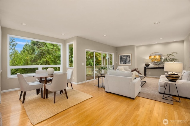 living room with a wealth of natural light, recessed lighting, and light wood-type flooring