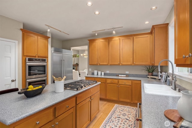 kitchen with recessed lighting, a sink, stainless steel appliances, light wood-type flooring, and a center island