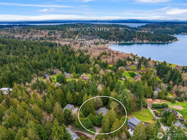 birds eye view of property with a water view and a wooded view