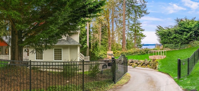 view of side of home with aphalt driveway, fence private yard, and a yard