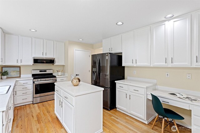 kitchen with white cabinets, light wood finished floors, and stainless steel appliances