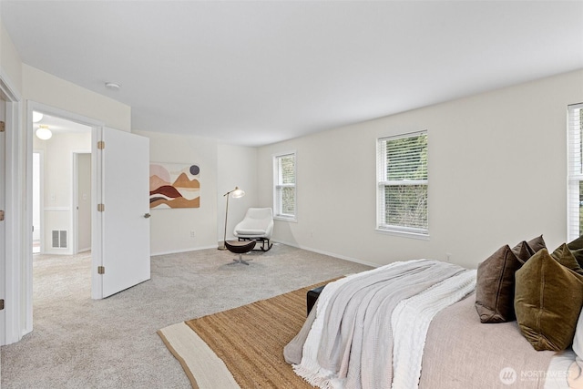 bedroom with visible vents, baseboards, and light colored carpet