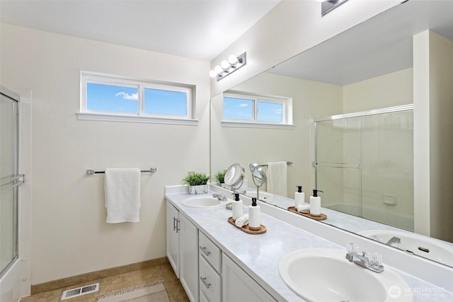 full bath with tile patterned floors, visible vents, double vanity, and a sink