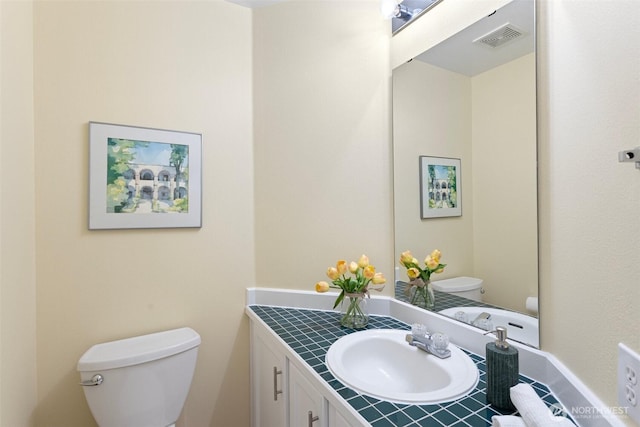 half bathroom with visible vents, toilet, and vanity