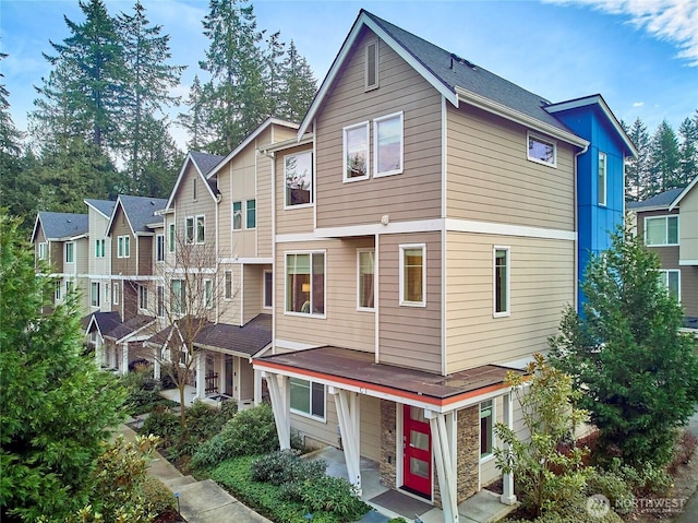 exterior space featuring stone siding and a residential view