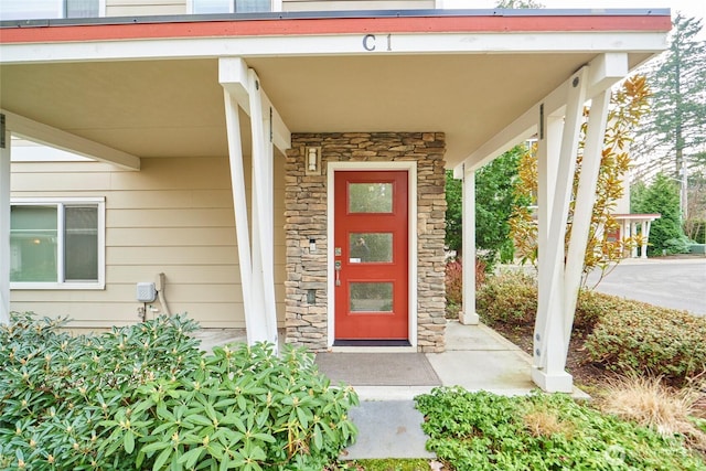 property entrance with stone siding and covered porch