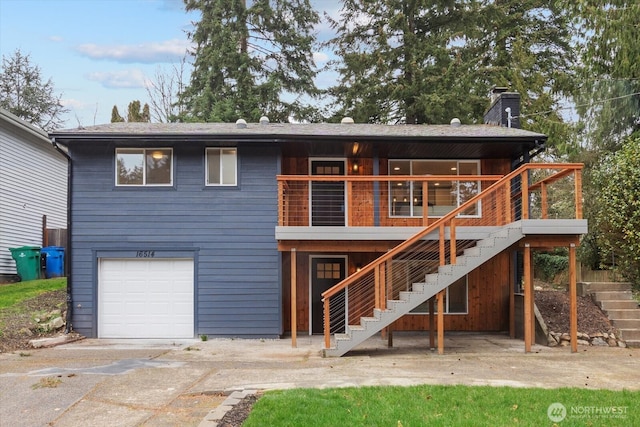 rear view of property with stairway, an attached garage, and a chimney