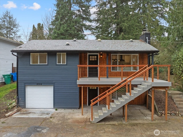 view of front of house featuring stairway, concrete driveway, a shingled roof, a garage, and a chimney