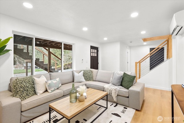 living room with recessed lighting, stairway, light wood-style flooring, and an AC wall unit