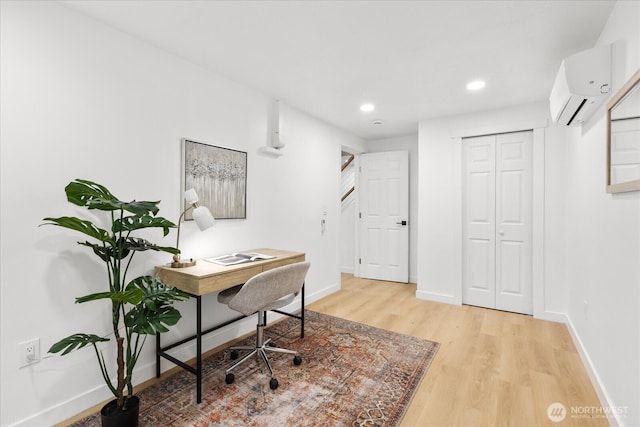 office space featuring recessed lighting, light wood-type flooring, baseboards, and an AC wall unit