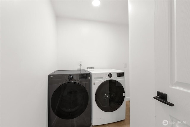 washroom featuring washer and dryer, laundry area, and light tile patterned flooring