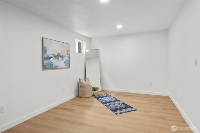 empty room featuring recessed lighting, wood finished floors, and baseboards