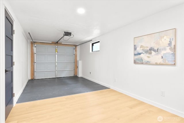 garage with a garage door opener and baseboards