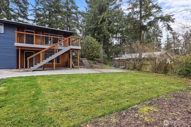 view of yard with a deck, stairway, a patio area, and fence