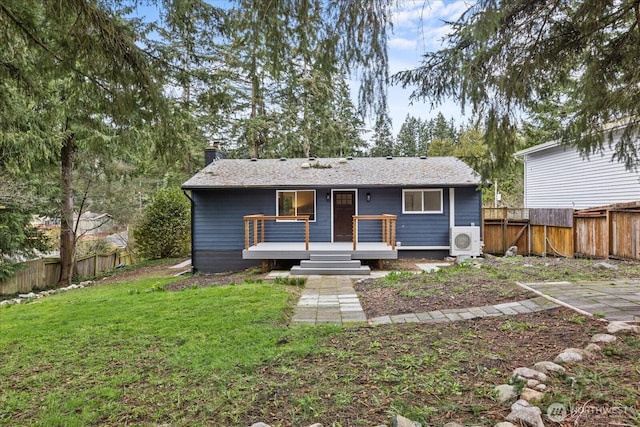 view of front of house with ac unit, a chimney, a fenced backyard, and a front yard