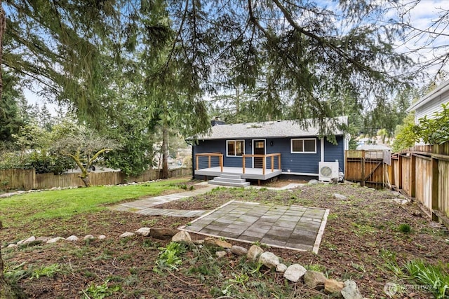 rear view of house featuring a wooden deck, ac unit, a chimney, a yard, and a fenced backyard