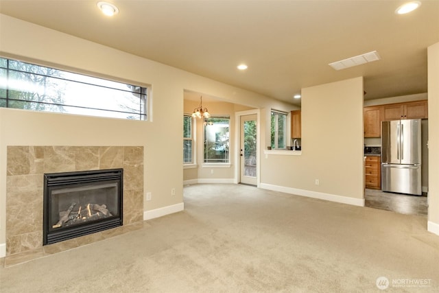 unfurnished living room with visible vents, baseboards, recessed lighting, a fireplace, and light colored carpet