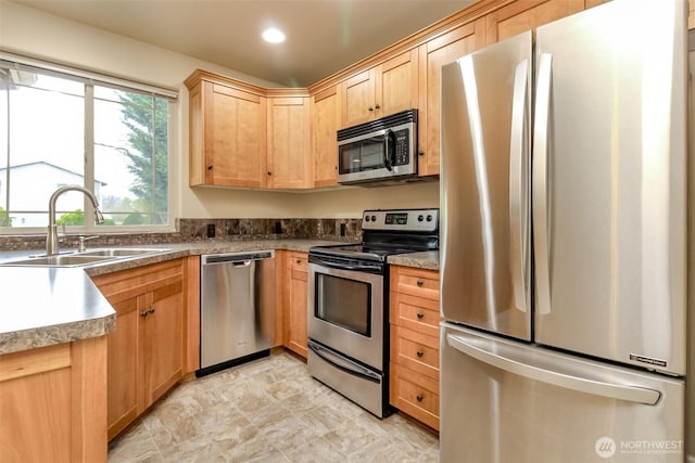 kitchen with a sink, recessed lighting, light brown cabinetry, and stainless steel appliances