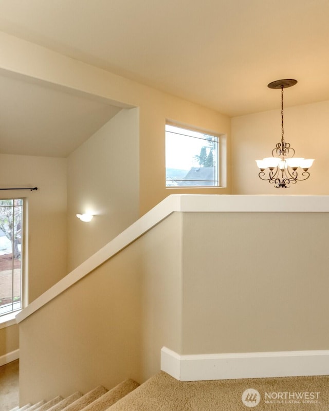 staircase with a notable chandelier