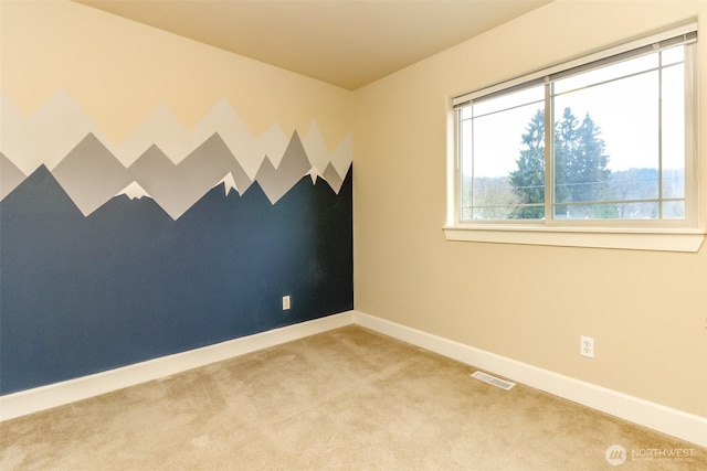 carpeted spare room featuring an accent wall, baseboards, and visible vents