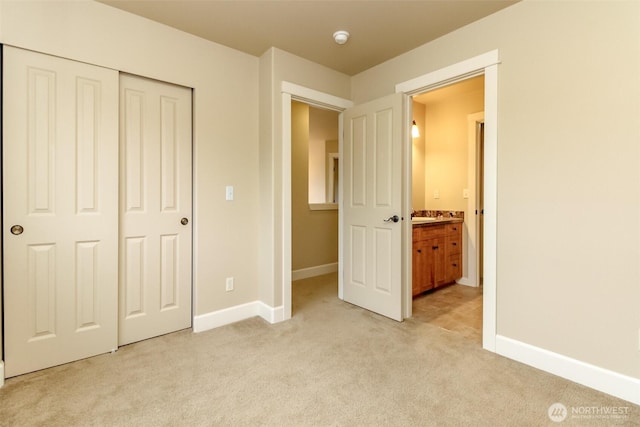 unfurnished bedroom with light colored carpet, a closet, and baseboards