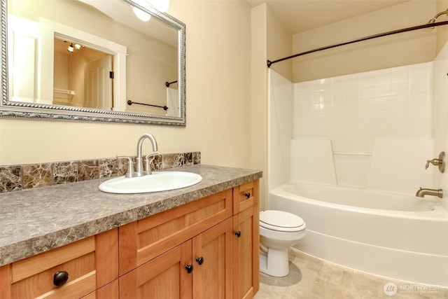 bathroom with tub / shower combination, toilet, and vanity