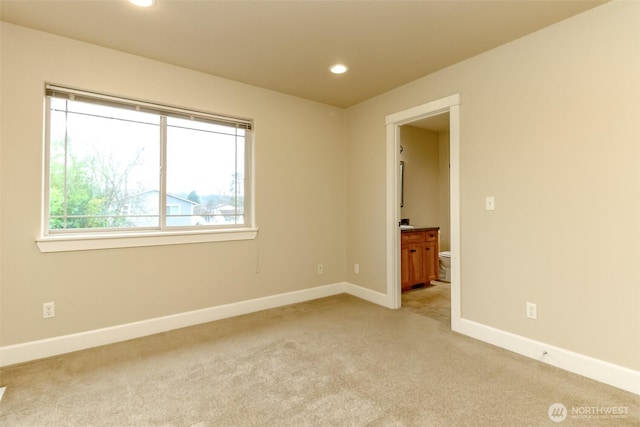 spare room with light carpet, recessed lighting, and baseboards