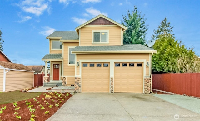 view of front of property featuring stone siding, a shingled roof, concrete driveway, and fence