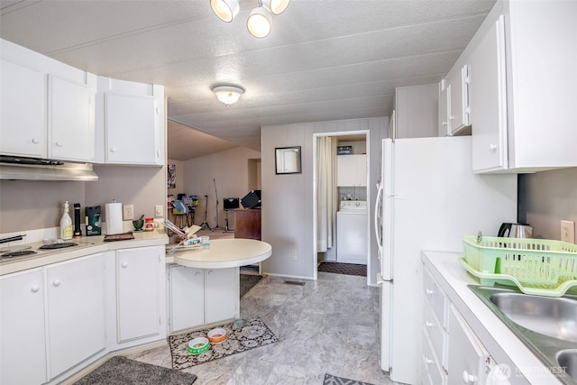 kitchen with cooktop, light countertops, white cabinets, and under cabinet range hood