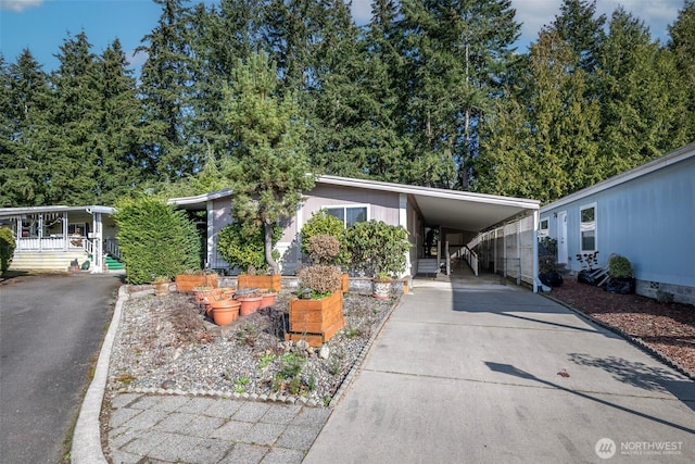 manufactured / mobile home with a carport and concrete driveway