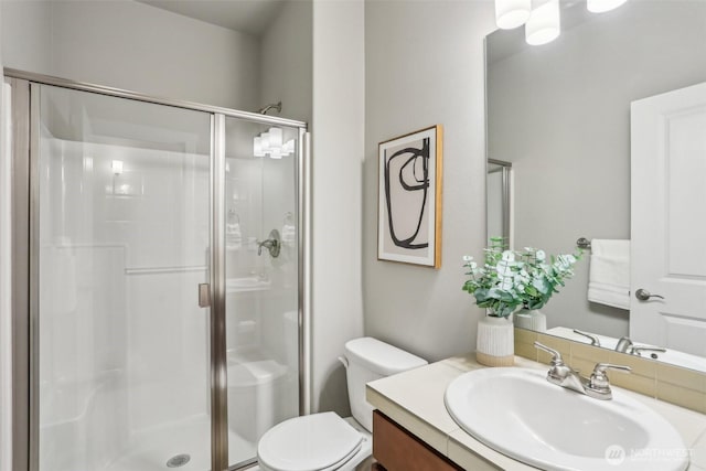 full bath featuring vanity, a shower stall, and toilet