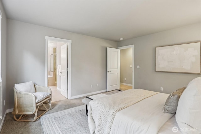 bedroom with light colored carpet, ensuite bathroom, and baseboards