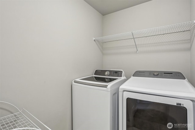 clothes washing area with washing machine and clothes dryer and laundry area