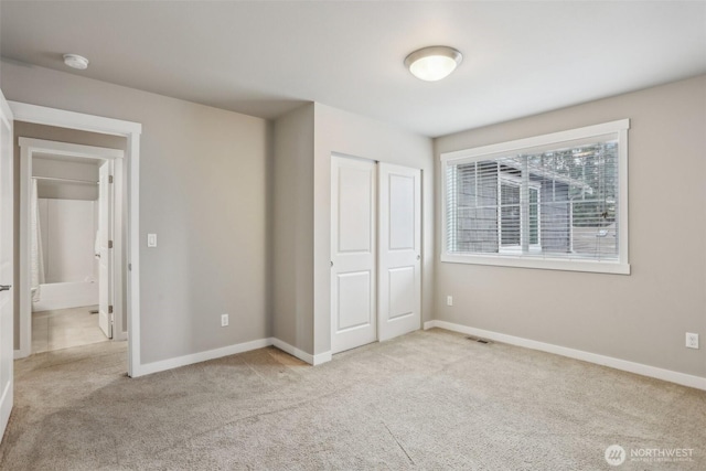 unfurnished bedroom featuring a closet, baseboards, visible vents, and carpet floors