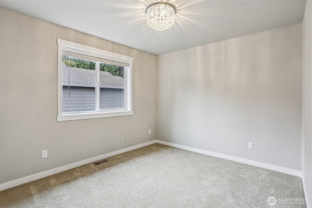 unfurnished room featuring visible vents, carpet floors, baseboards, and a chandelier