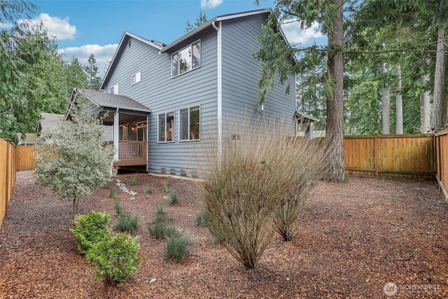 rear view of property featuring a fenced backyard