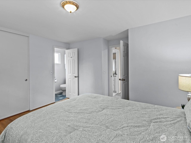 bedroom with wood finished floors and ensuite bath