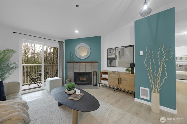 975 Aberdeen Ave NE Unit F407, Renton, WA 98056 - living area with wood finished floors, visible vents, baseboards, recessed lighting, and a tiled fireplace