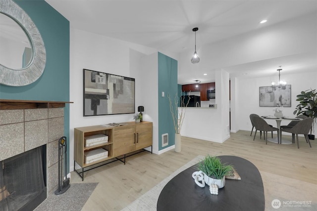 975 Aberdeen Ave NE Unit F407, Renton, WA 98056 - living room featuring wood finished floors, visible vents, recessed lighting, a tile fireplace, and a notable chandelier