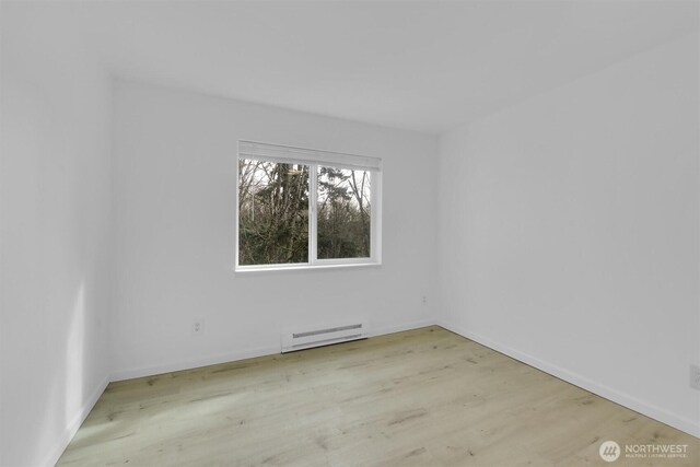 975 Aberdeen Ave NE Unit F407, Renton, WA 98056 - spare room featuring wood finished floors, baseboards, and a baseboard radiator