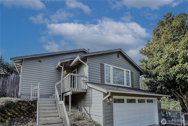 view of front of house with stairway, fence, and a garage