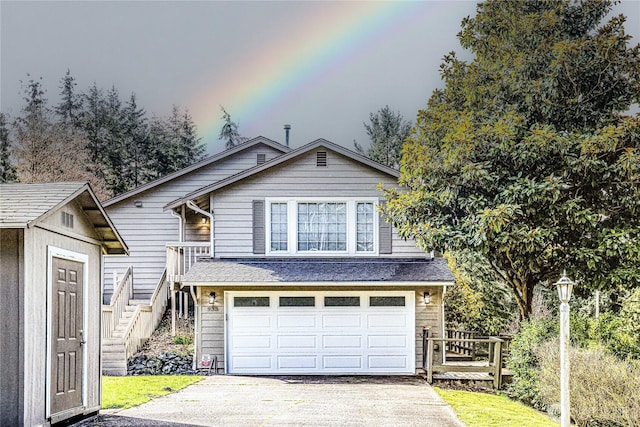 view of front of house featuring an attached garage, stairs, concrete driveway, an outdoor structure, and a storage shed