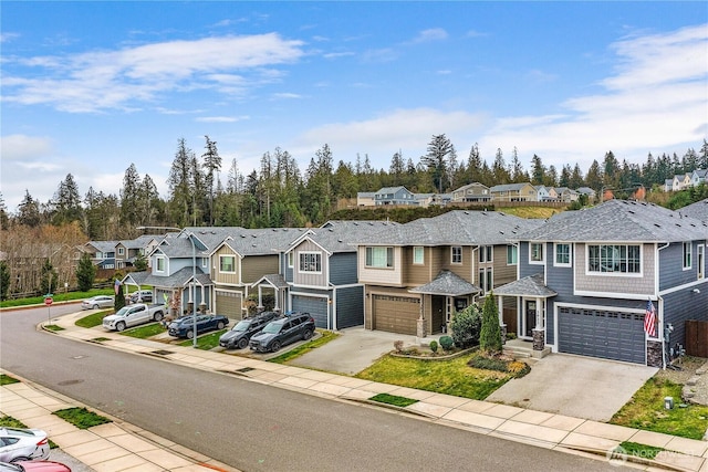 view of property featuring a garage, a residential view, and driveway