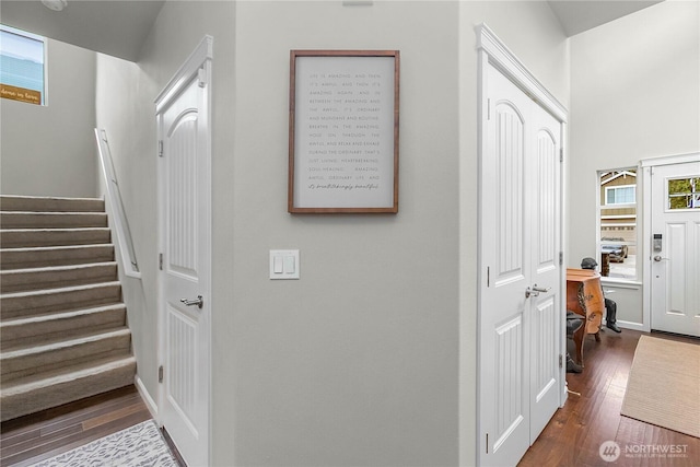 corridor featuring dark wood-type flooring and stairs