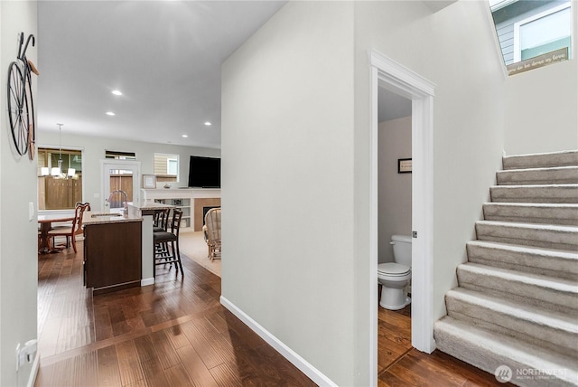 interior space with stairs, an inviting chandelier, recessed lighting, and dark wood-style flooring