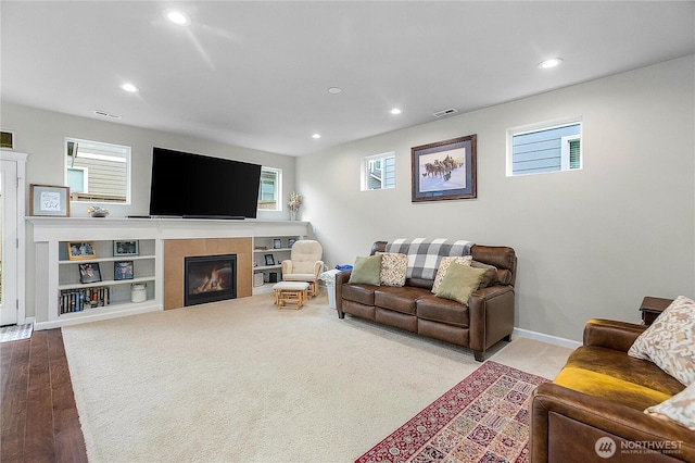 living area with a fireplace, recessed lighting, visible vents, and baseboards