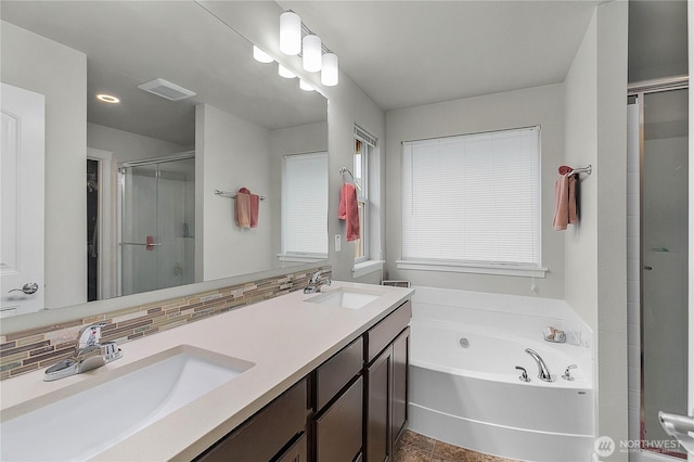 bathroom featuring a stall shower, a bath, visible vents, and a sink