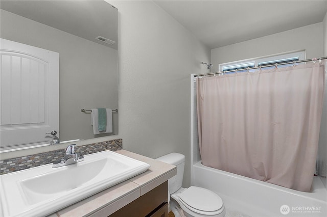 bathroom with visible vents, toilet, vanity, and shower / tub combo with curtain